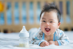 Asian_Newborn_baby_smile_with_milk_power_bottle.jpeg