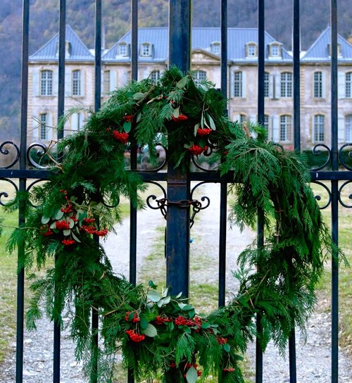 Fresh green wreath hangs on the iron gate of Chateau Gudanes. South of France Fixer Upper Château Gudanes. #southoffrance #frenchchateau #provence #frenchcountry #holidaydecor #wreath