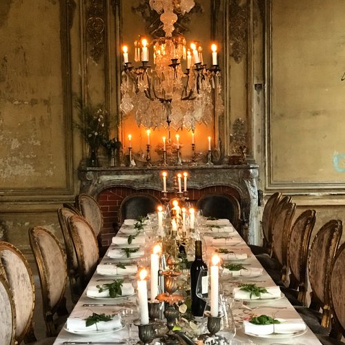 Romantic dining table with oval back dining chairs and crystal chandelier in a French chateau. South of France Fixer Upper Château Gudanes. #southoffrance #frenchchateau #provence #frenchcountry #renovation