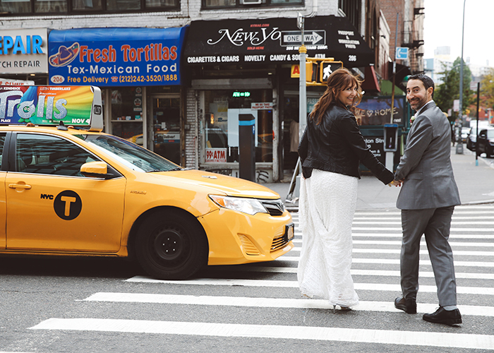 newlywed couple holding hands walking across street in new york city