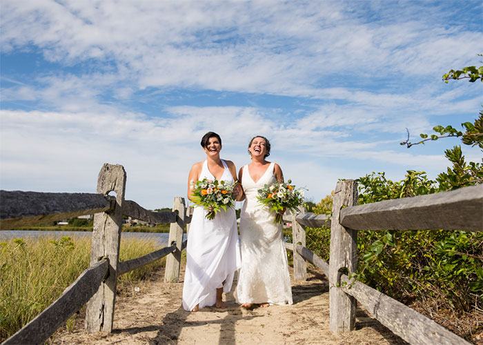 two brides walking on sandy path at beach boston massachusetts