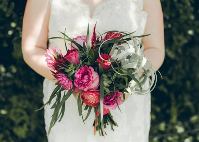 bride holding bouquet of roses and succulents