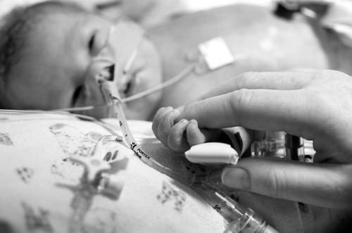 NICU baby intubated IV holding mothers finger
