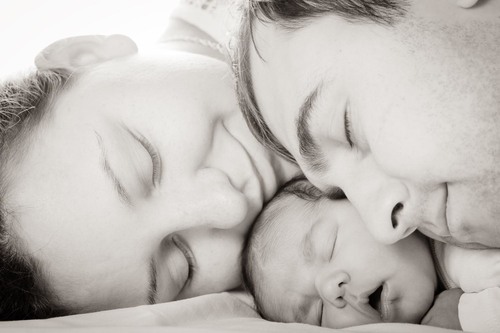 NICU mom and NICU dad snuggling with preemie