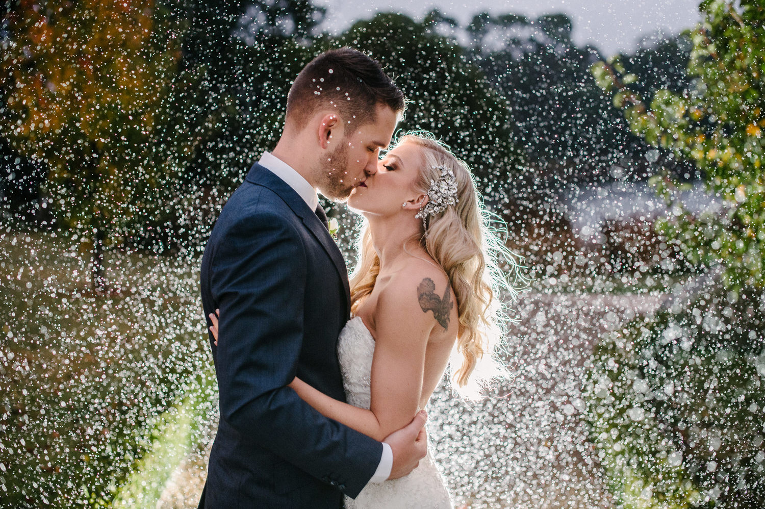 Bride and groom sharing a kiss at their rainy day wedding
