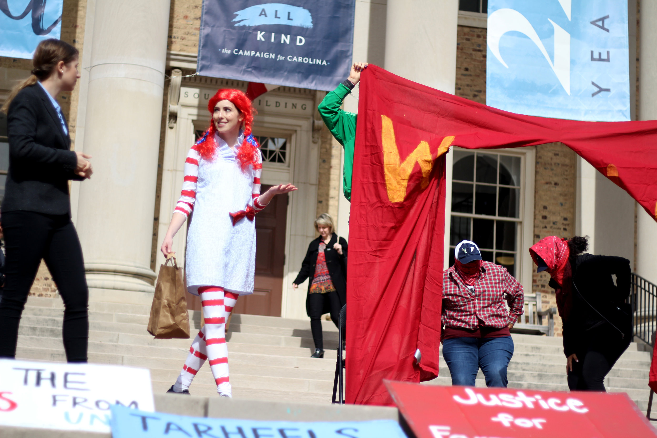  Students at University of North Carolina at Chapel Hill stage a theater skit on the steps of UNC Chancellor Folt’s office to highlight the University’s complicity in human rights abuses. 