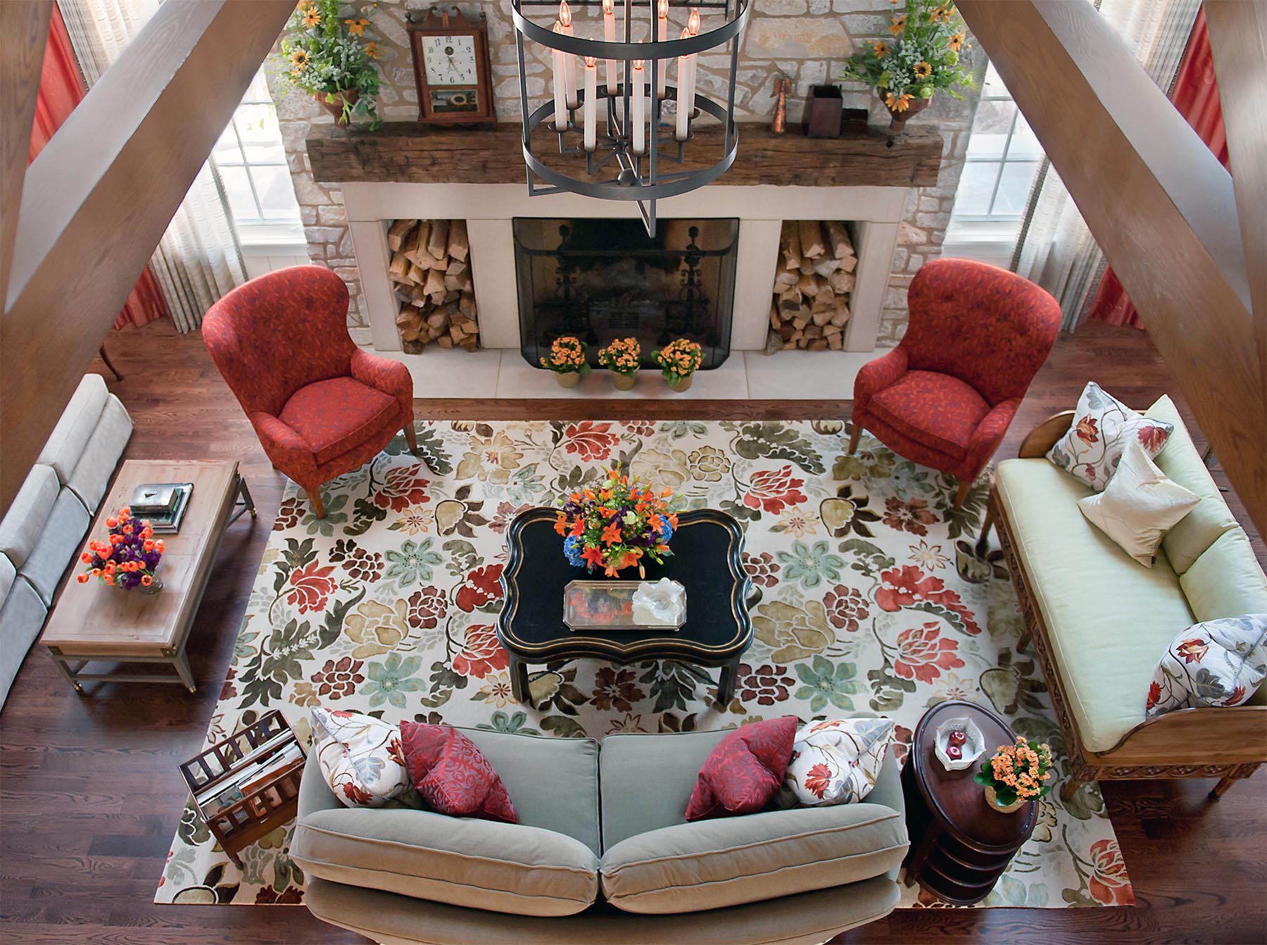 Magnificent aerial view of a cheerful lodge style living room with coral chairs and vibrant floral rug. Come see more interior design inspiration from Elizabeth Drake. Photo by Werner Straube. #interiordesign #classicdesign #traditionaldecor #housetour #elizabethdrake
