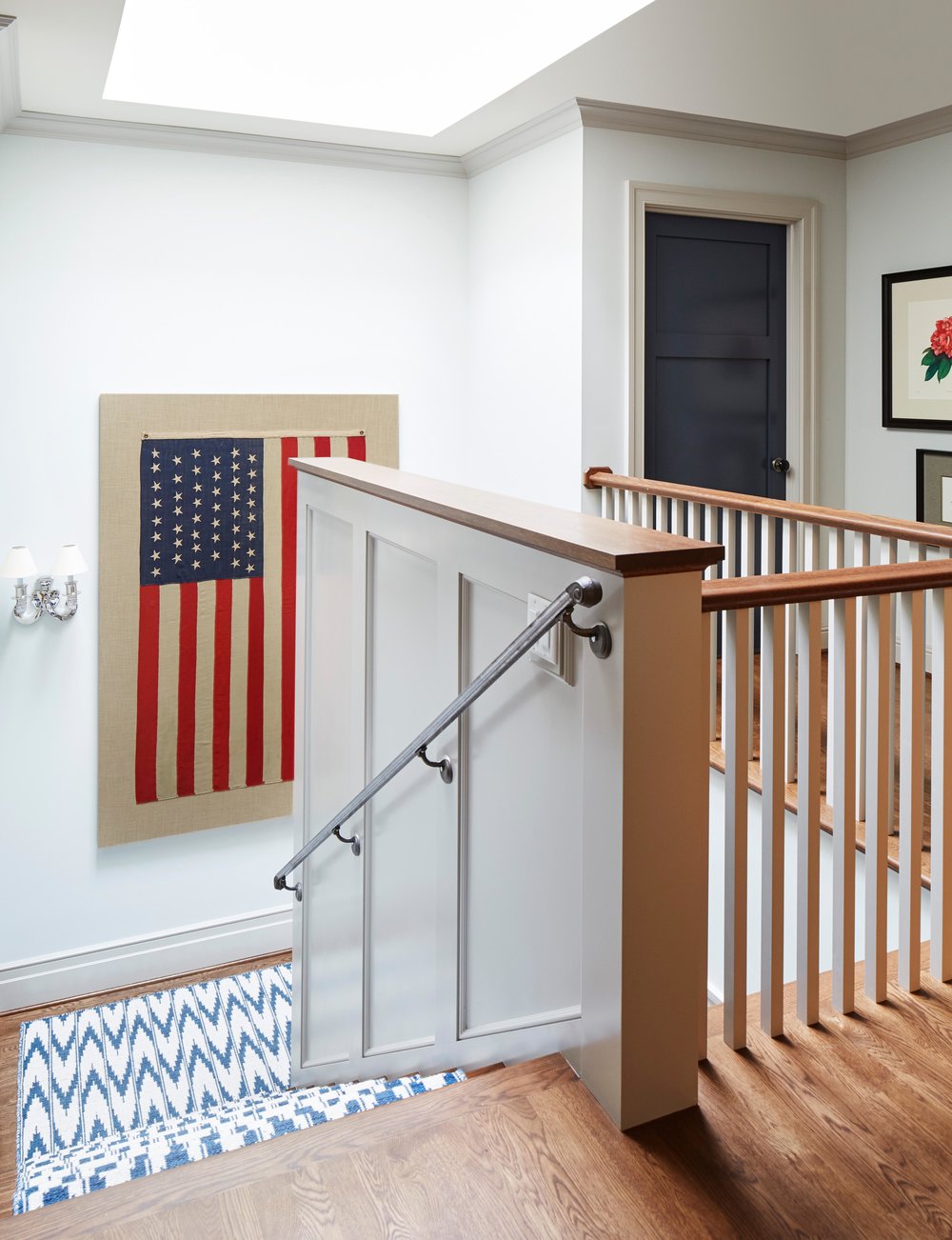 American flag framed on wall near staircase. Come see more interior design inspiration from Elizabeth Drake. Photo by Werner Straube. #interiordesign #classicdesign #traditionaldecor #housetour #elizabethdrake