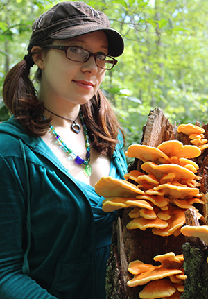 Emily Schmidt with an orange-and-yellow sun fungus. (Ryan Bouchard)