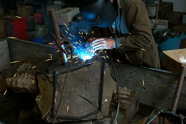 Tellel Waldhaus welding a steel encasing onto one of three Drusy Quartz specimens.