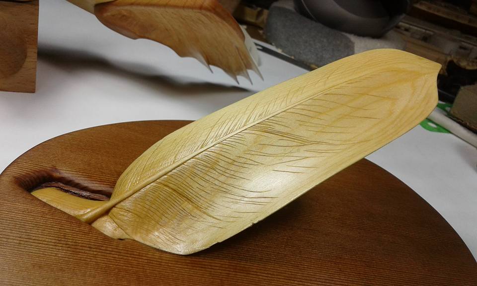 When placed by light, this thinly carved feather is illuminated. T