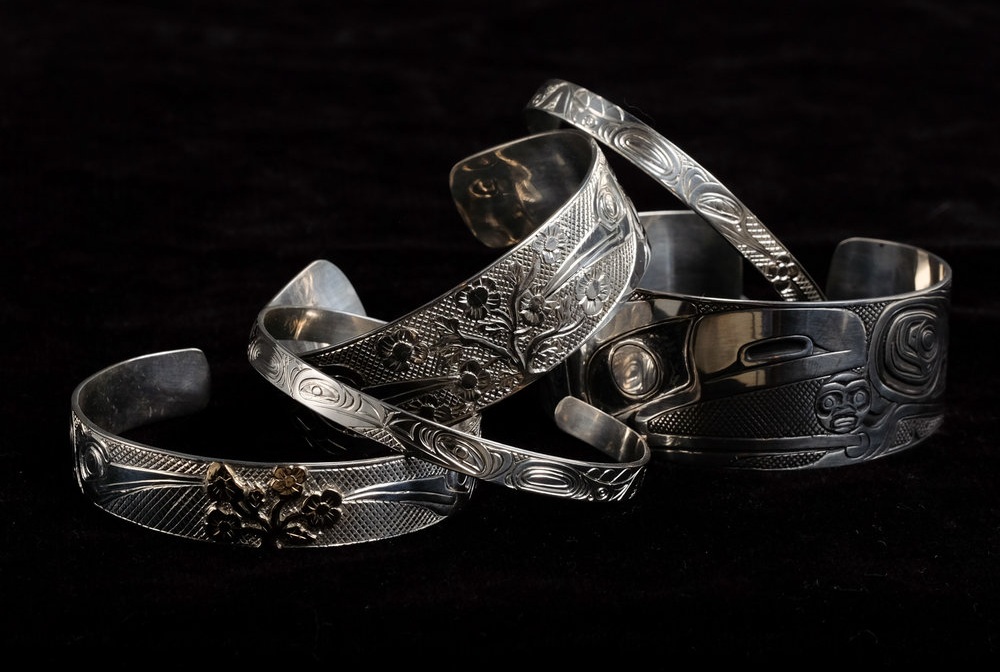 A variety of sterling silver and 14K gold bracelets in widths ¼ inch, ½ inch. ¾ inch, 1 inch, by Haida artists, Carmen Goertzen and son Neil Goertzen.