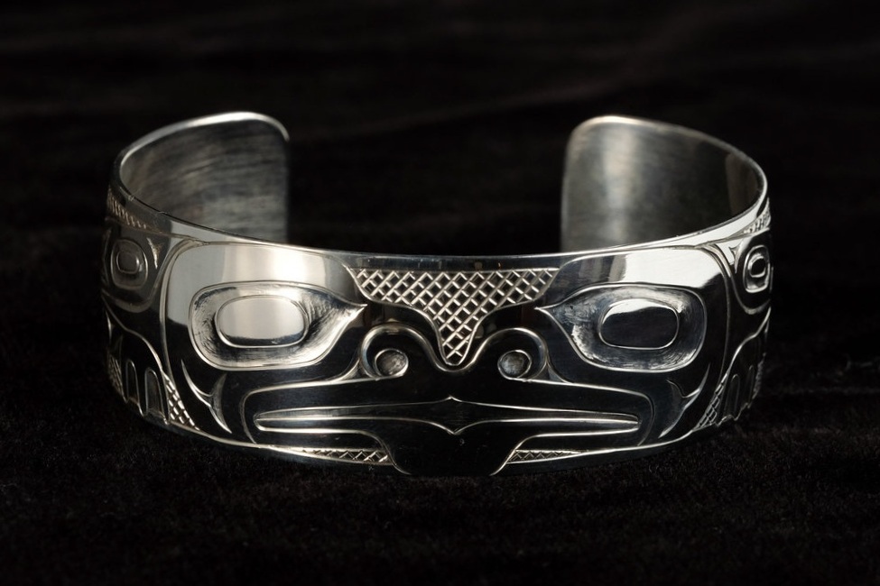 This sterling silver frog bracelet was carved by Haida carver, Derek White, who is from Old Massett, Haida Gwaii. This bracelet measures 3/4 inch wide and 6 1/4 inches long.