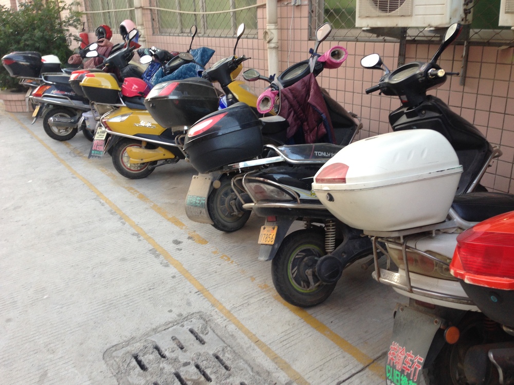 Production line workers' scooters outside the textiles factory in China