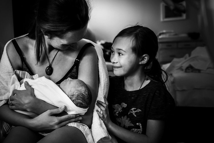 This big sister watched with pride as her mom birthed her baby brother into the world. Image by Monet Nicole - Birthing Stories. 
