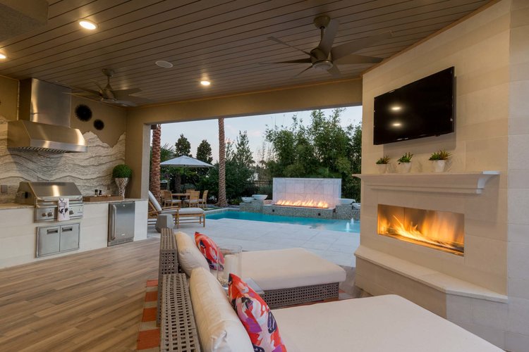 Boomer buyer model home patio with outdoor kitchen, pool and lounge seating