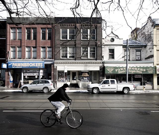 A man bikes down Church Street