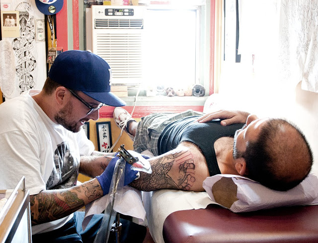 Passage Tattoo Parlour as a client helps a customer with his new tats