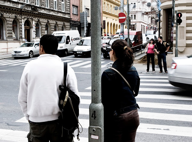 Two couples crossing at an intersection in Prague