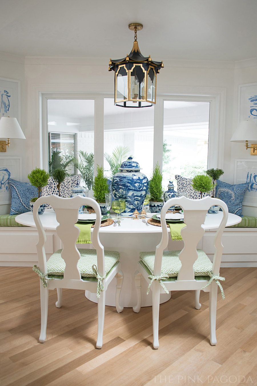 Banquette dining with blue and white created for The Pink Pagoda's One Room Challenge™. Art by Christina Baker, Coleen & Company pagoda lantern, and tabletop styling by Susan Palma.