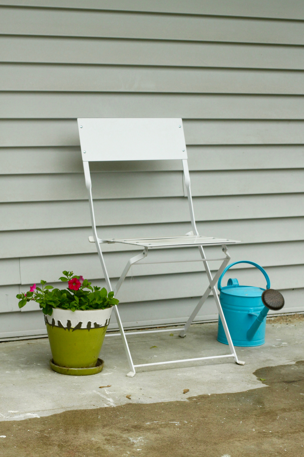 Garden chair, watering can, and flowers