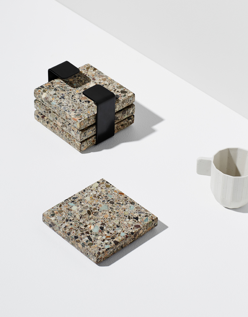 Habitat Set - Habitat is a 4-piece trivet set, made from natural, earthy Terrazzo stone. Finished with a steel band to house them when not in use. They make a textural addition to any tabletop. Use them as individual coasters or piece together for a larger trivet.
