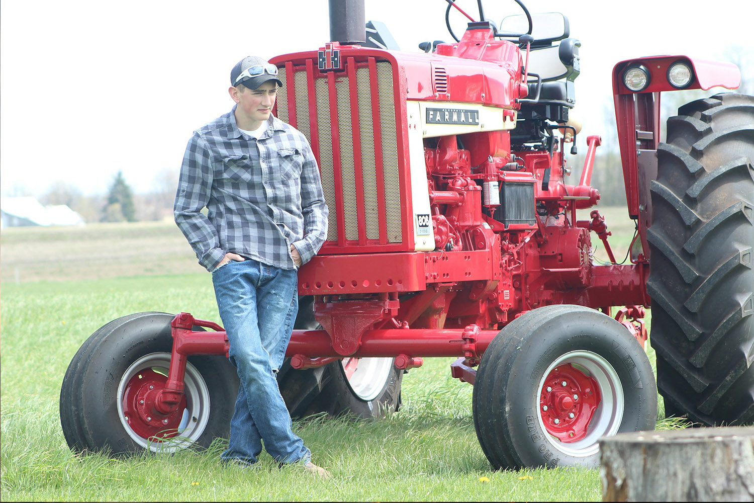 picture of a farmer standing beside a tractor