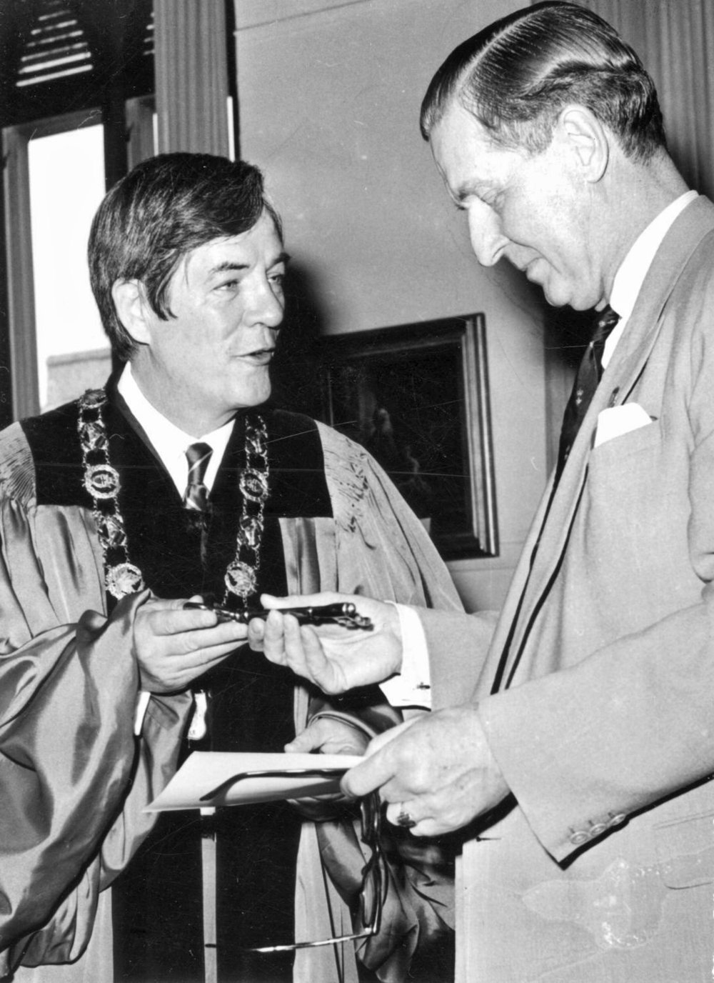 Russell Scott, wearing chain of office as mayor of Belleville, is shown presenting the key to the city to an unidentified recipient. Dr. Scott was distinguished by an approachable and down-to-earth demeanour. Photo courtesy of Belleville and Hastings County Community Archives.