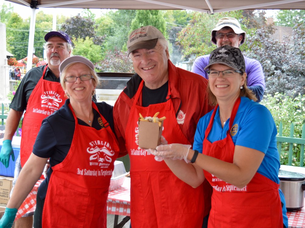 The Stirling Lions and Stirling Rotary clubs joined forces to create one of the busiest and most successful food booths at the 2016 festival. Hugh Hoard (Lions) is flanked by Rotarians Donna Graff and Shelley Hagerman (holding the Water Buffalo Poutine) as Dean Graff and Bill Lewis look on.