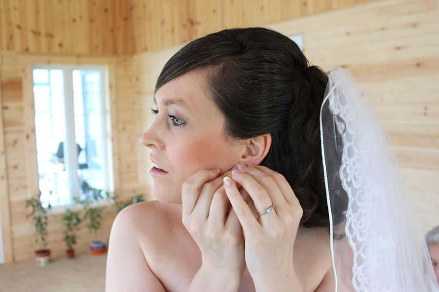 bride putting earrings on
