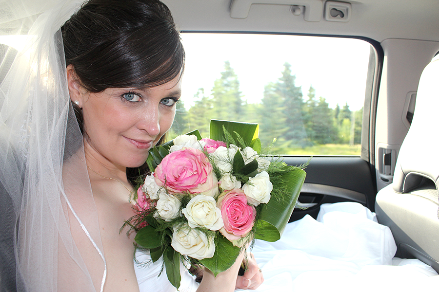 bride in car with pink roses