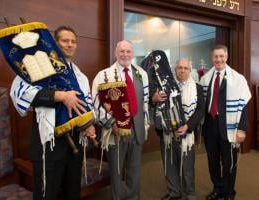 Sister Scrolls from Prestice held by Art Newman of Temple Israel; Jeffrey Ohrenstein, Chairperson of the Memorials Scroll Trust, London; Bob Sofer of Temple Sinai; and Rabbi Joseph Meszler of Temple Sinai.