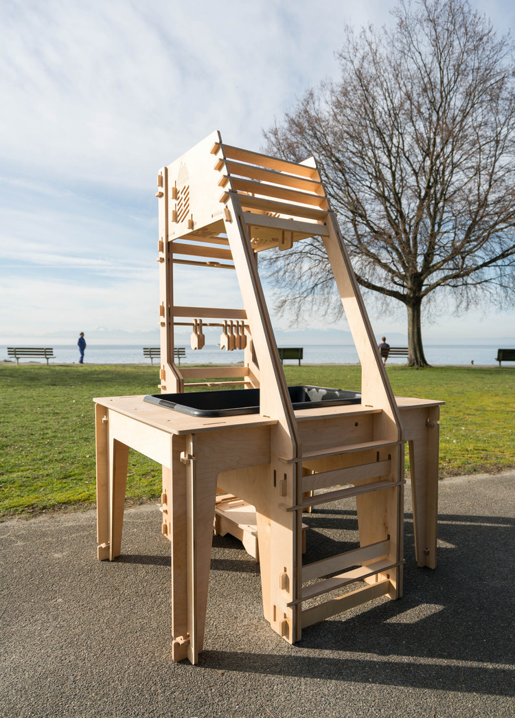 A photo of a wooden AR sandbox frame outside on asphalt, but with no projector attached