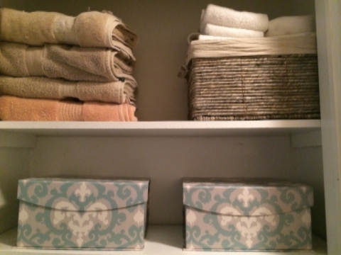 Linen closet. Smaller towels folded and placed in a basket keep them from falling over or getting in the way. Magnetic fiberboard boxes allow for decorative storage of medicine and first aid products as well as back up toiletries (toothpaste, toothbrushes, etc.)