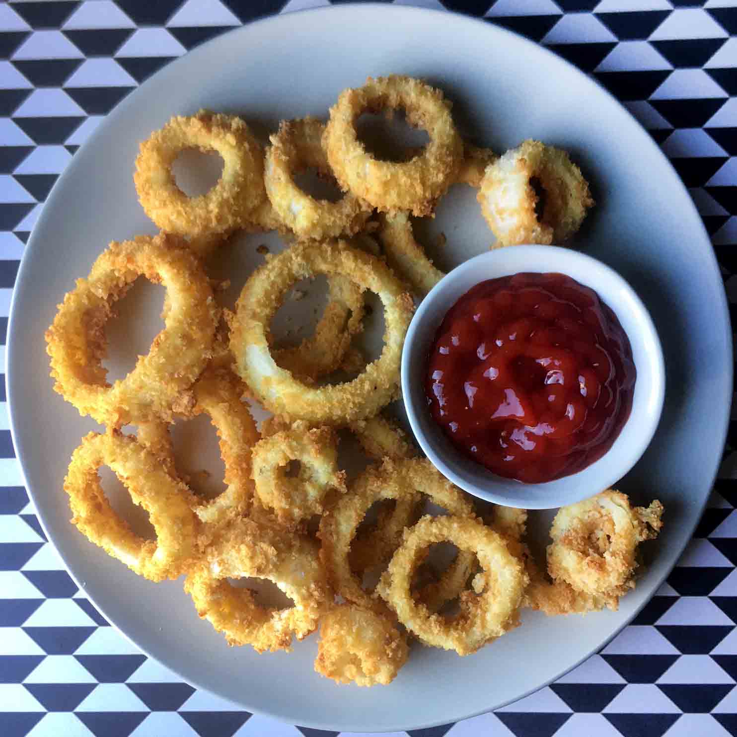 A plate of Keto onion rings with a small bowl of ketchup