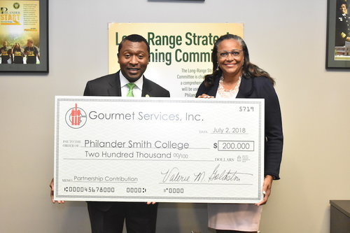 Photo of two people holding a large check.