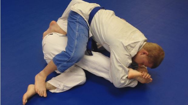 A larger, stronger trainee footlocks his opponent.