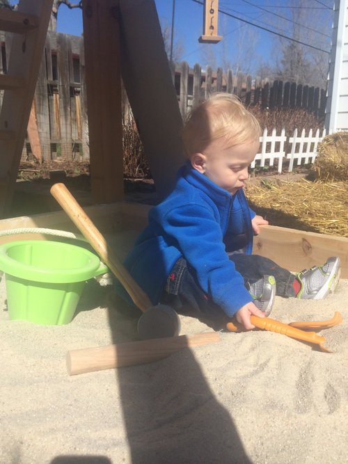 Thomas enjoying the new sandbox under the slide