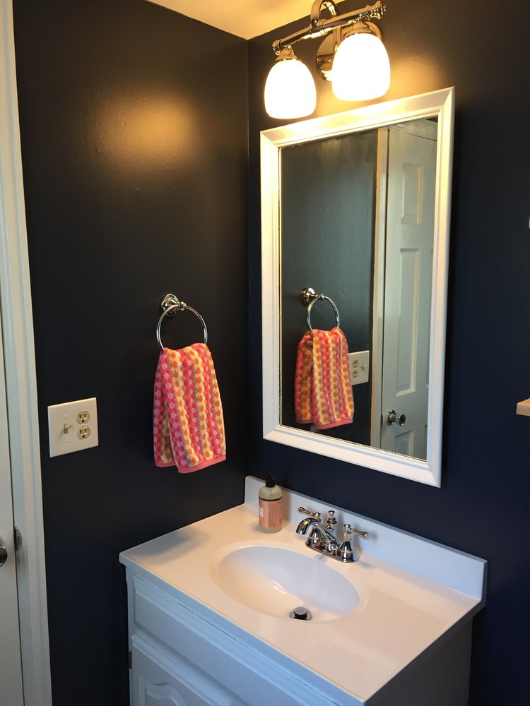 Updated bathroom vanity with painted mirror and new light fixture.
