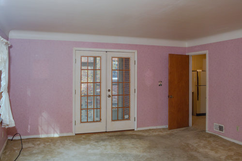 Before photo with old carpet and pink wallpaper