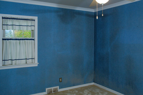 Before. the first floor bedroom was filthy from smoke and the blue wallpaper and dirty carpet had to go.