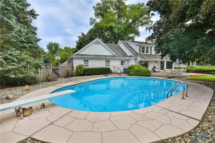 The backyard includes a built in pool with a diving board.