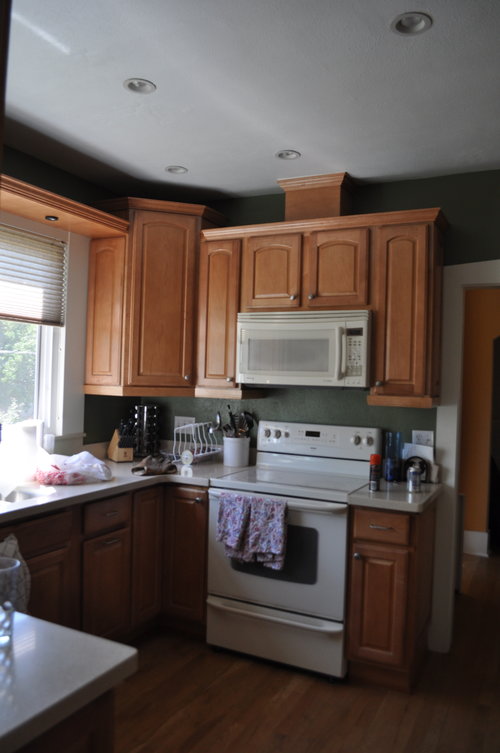 The kitchen before felt very small with the dark green paint and white appliances.