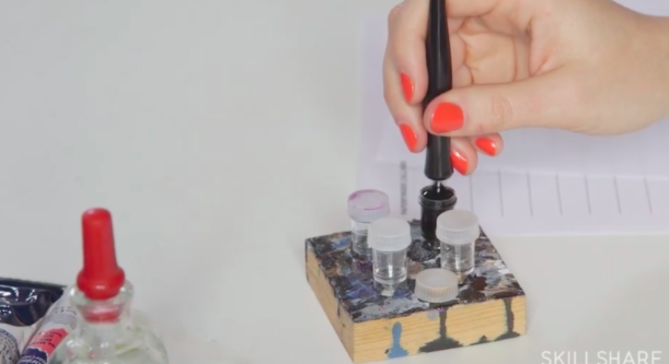 Skillshare instructor Bryn Chernoff demonstrates how to properly dip a nib pen. Dip past the reservoir on the nib, but make sure not to dip as far as the nib holder. 