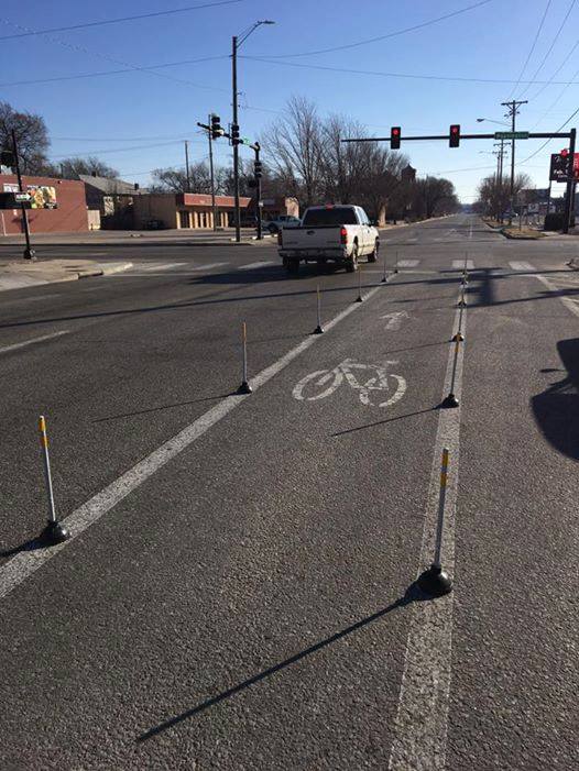 The "mysterious plungers" lined each side of the bike lane at the intersection of 1st & Washington to prevent drivers from illegally encroaching on the bike lane to make a right turn. 