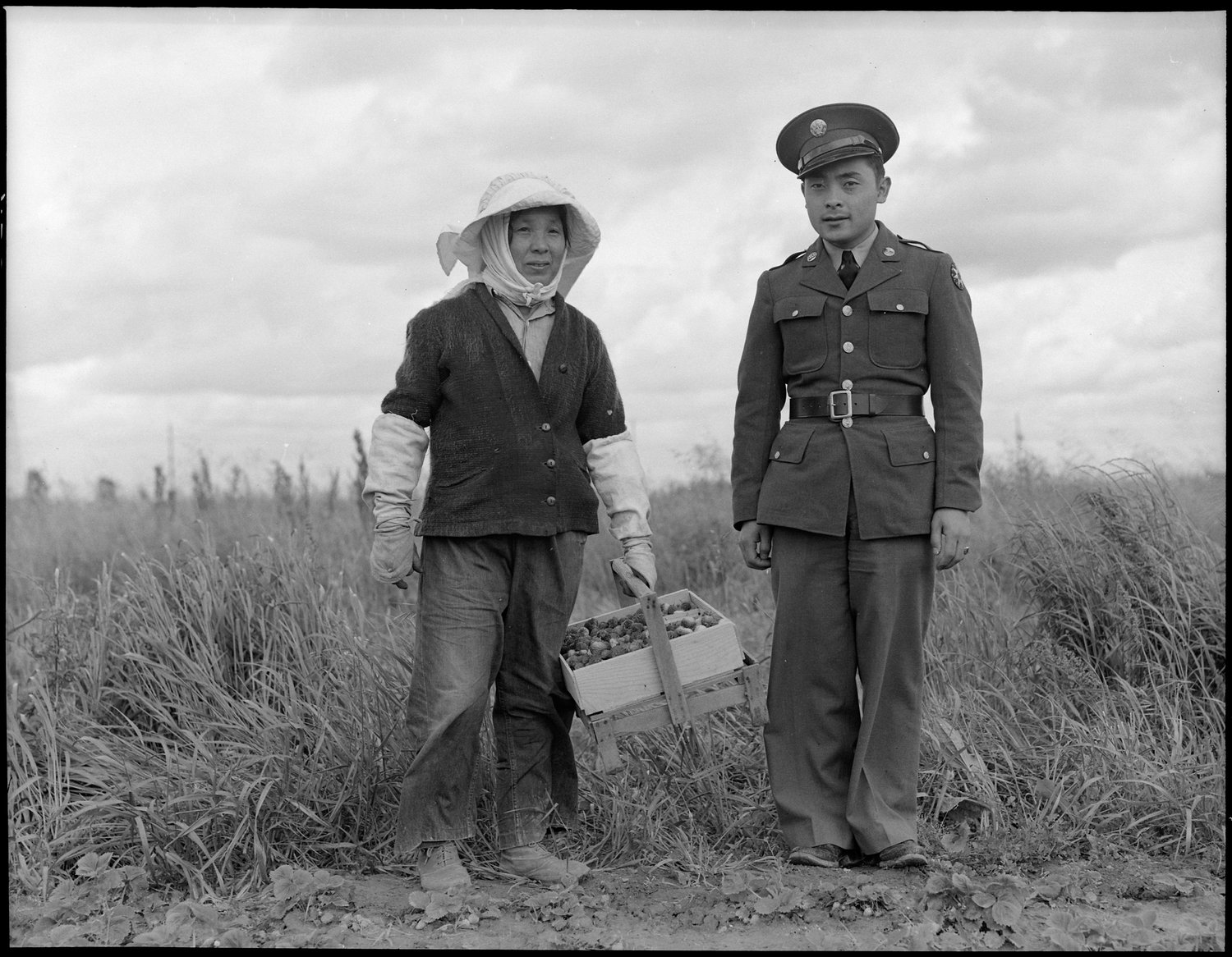  Florin, Sacramento County, California. A soldier and his mother in a strawberry field. The soldier, age 23, volunteered July 10, 1941, and is stationed at Camp Leonard Wood, Missouri. He was furloughed to help his mother and family prepare for their evacuation. He is the youngest of six years children, two of them volunteers in United States Army. The mother, age 53, came from Japan 37 years ago. Her husband died 21 years ago, leaving her to raise six children. She worked in a strawbery basket factory until last year when her her children leased three acres of strawberries "so she wouldn't have to work for somebody else". The family is Buddhist. This is her youngest son. Her second son is in the army stationed at Fort Bliss. 453 families are to be evacuated from this area. 