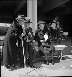  San Bruno, Caliofnira. These older evacuees of Japanese ancestry have just been registered and are resting before being assigned to their living quarters in the barracks. The large tag worn by the woman on the right indicates special consideration for aged or infirm. 