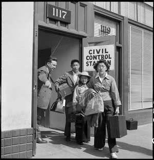  Oakland, California. Part of family unit of Japanese ancestry leave Wartime Civil Control Administration station on afternoon of evacuation, under Civilian Exclusion Order Number 28. Social worker directs these evacuees to the waiting bus. 