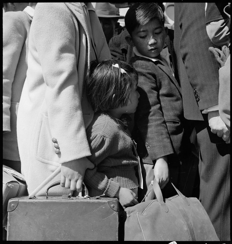 PRINT AVAILABLE May 2, 1942 — Byron, California. Third generation of American children of Japanese ancestry in crowd awaiting the arrival of the next bus which will take them from their homes to the Assembly center.