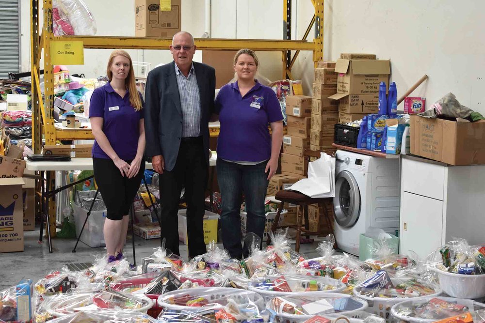  Menzies Caring For Kids president Kevin Johnson and MSFIN members Jodie Harris and Donna Cartwright inspect some of the hampers prepared for distribution to 400 families last Christmas. 